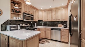 A modern kitchen with wooden cabinets, a stainless steel refrigerator, a microwave, a toaster, and a sink. - On Mountain two bedroom unit sleeping 6 (Newry)