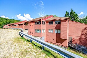 A row of red motel buildings with a metal guardrail in front.