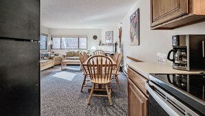 A modern kitchen with a black refrigerator, wooden cabinets, and a microwave. - On Mountain two bedroom unit sleeping 6 (Newry)
