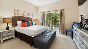 A bedroom with a large bed, a bench, a dresser, and a view of the outdoors through a sliding door. - Cheerful Condo - minutes away from Disney/ with Pools, Resturant & Spa (Davenport)