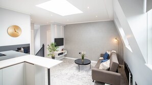 Luxe appartement, 1 tweepersoonsbed met slaapbank, uitzicht op de stad | Woonruimte | Een 42-inch flatscreentelevisie met satellietzenders en televisie