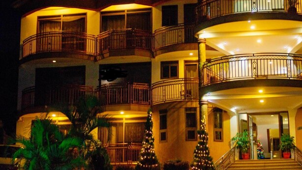 A multi-story hotel with balconies, a central staircase, and Christmas decorations. - Hotel Lemonade (Kampala)