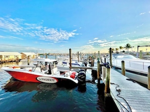 A marina with boats docked, a clear sky, and a distant cityscape. - Waterfront Condo + Pool Downtown + Boat Slip (Key West)
