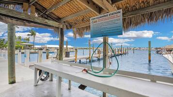 A fish cleaning station with a sign, wooden structure, and water.