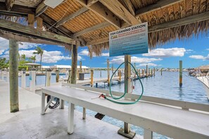 A fish cleaning station with a sign, wooden structure, and water. - Waterfront Condo Dock Pool Downtown Near Duval (Key West)