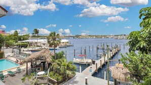 A marina with docked boats, a swimming pool with lounge chairs, and a view of the water and distant buildings. - Waterfront Dock Pool Key West Near Duval (Key West)