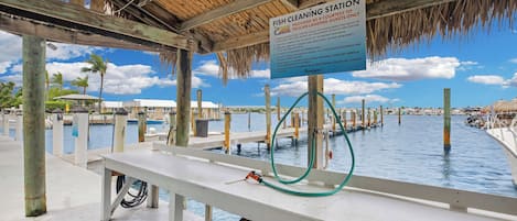Estación para limpiar pescado con un letrero, estructura de madera y agua.