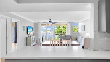 Une cuisine spacieuse avec un grand îlot central, un coin repas offrant une vue agréable et un balcon avec vue.