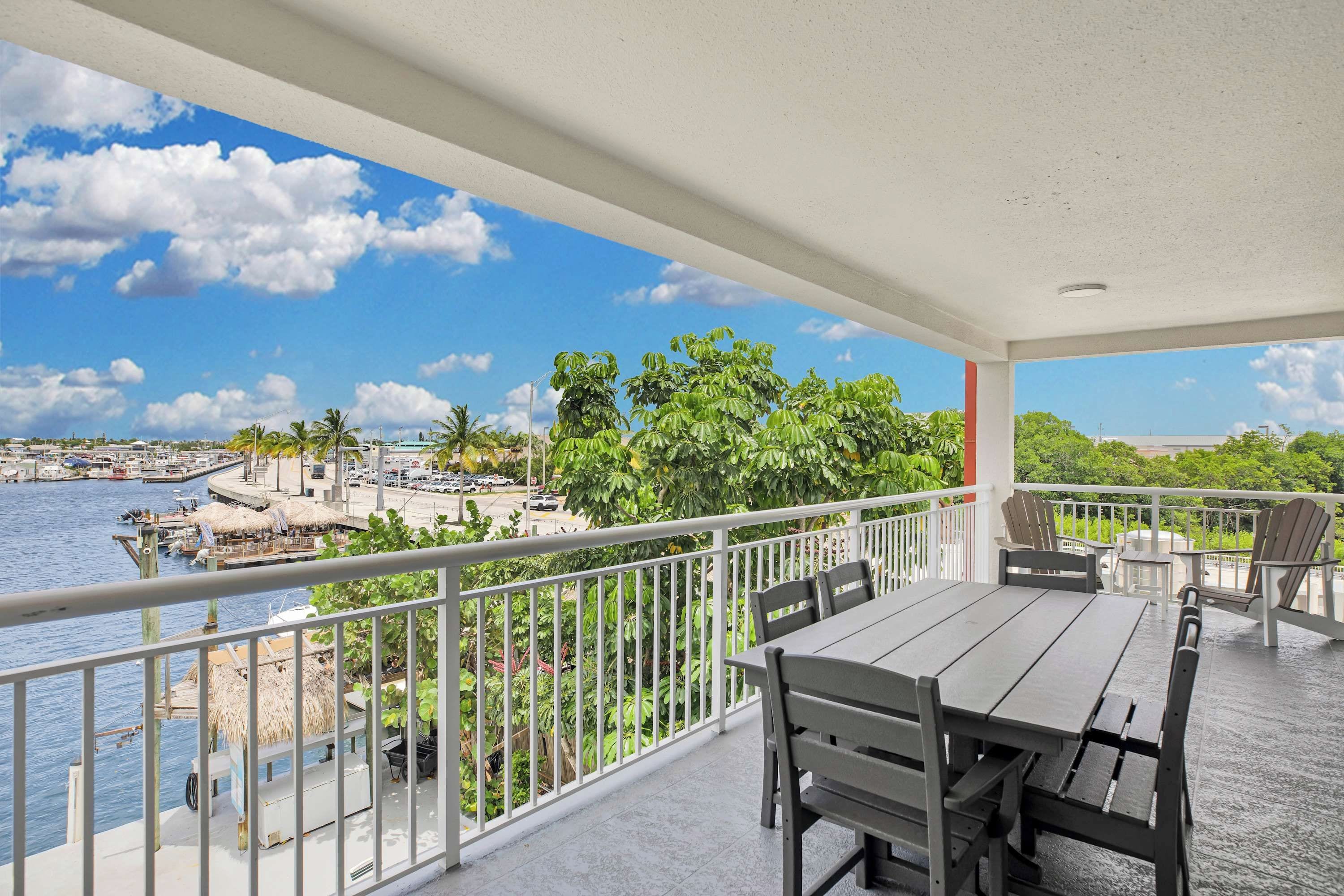 Ein überdachter Balkon mit Blick auf einen Hafen und die Uferpromenade.