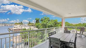 Ein überdachter Balkon mit Blick auf einen Hafen und die Uferpromenade.