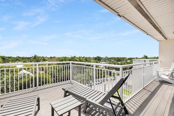 A balcony with a view of a residential area, including houses and greenery.