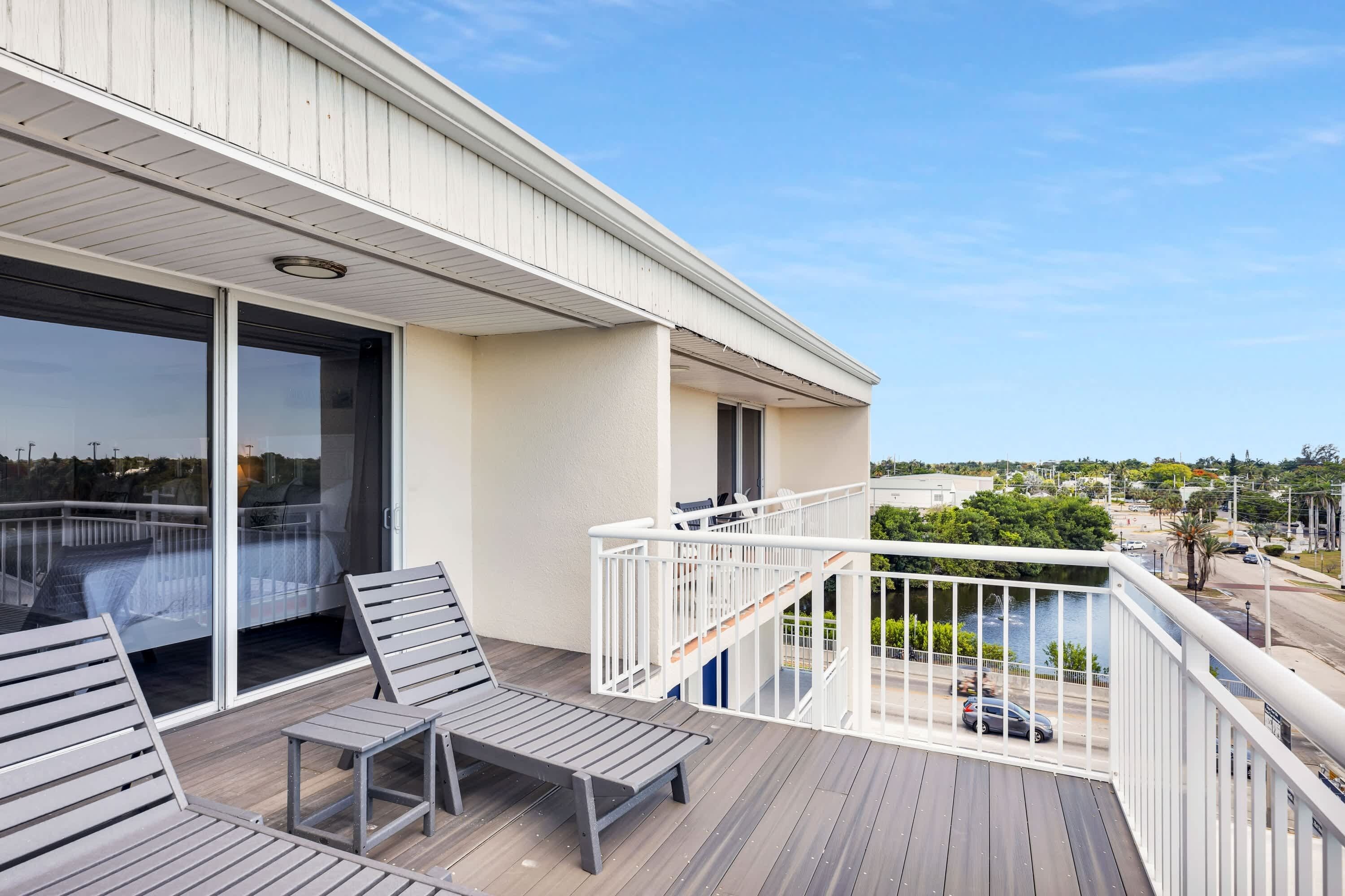 A balcony with a view of a body of water and a cityscape.