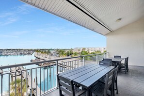 Un balcón con vista a un puerto deportivo y un edificio a lo lejos.