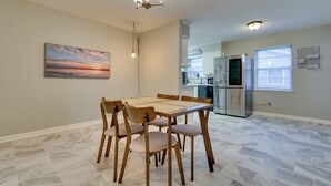 A dining area with a wooden table and chairs, a chandelier, a painting, and a kitchen in the background. - 7 Mi to Dtwn: Little Rock Home Near Interstate (Little Rock)
