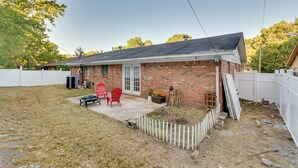 A single-story brick house with a covered patio, a white picket fence, and a small garden area. - 7 Mi to Dtwn: Little Rock Home Near Interstate (Little Rock)