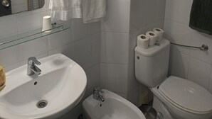 A bathroom with a sink, bidet, toilet, and a mirror. - H. Central Funchal III (Funchal)