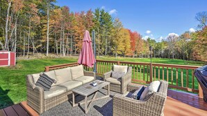 Une terrasse extérieure avec des meubles en osier, une table et un barbecue.