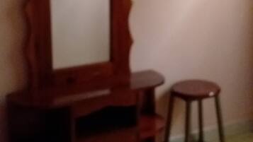 A wooden dresser with a mirror and a stool.
