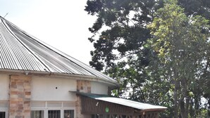 A building with a metal roof, stone walls, and a wooden structure with lattice work.