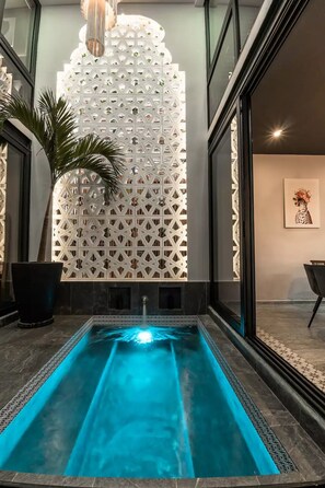 Ein moderner Innenpool mit geometrischer Wandgestaltung und einer klaren, blauen Wasserspülung.