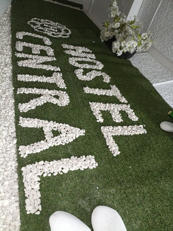 A hotel carpet with the name 'HOTEL CENTRAL' spelled out in white pebbles.