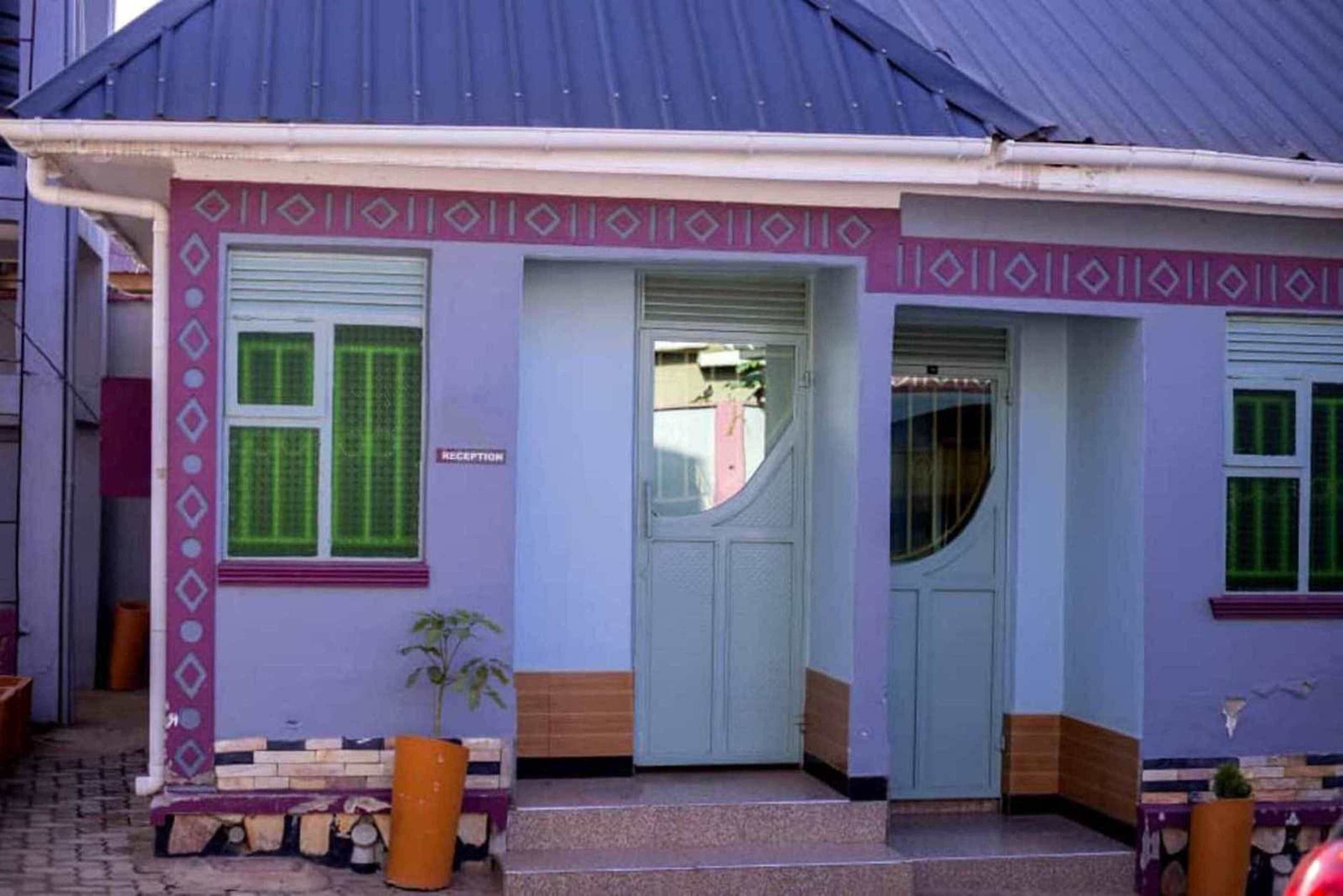 A building with a reception area, a door, and a window with green shutters.