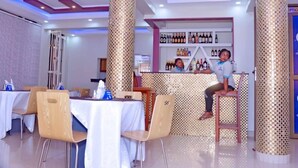 Ein Restaurant mit hohen Decken, dekorativen Säulen und einer Bar mit einer Auswahl an Flaschen.