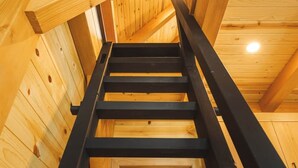 A wooden staircase leading to a door in a log cabin interior. - #8 Cottonwood Corner (Dahinda)
