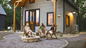 A wooden cabin with a stone fire pit, large windows, and outdoor seating. - #20 Bluegill Cove (Dahinda)
