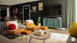 Una sala de estar moderna con un sofá, sillones, una otomana y una mesa de centro.