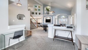 A modern living room with a pool table, a TV, and a staircase leading to an upper level. - Bright&Open, Lrg home @DIA w/Pool Table & Firepit (Denver)