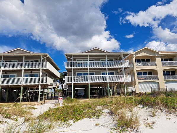 Ett hotell vid stranden med flera balkonger och en sandstrand framför.