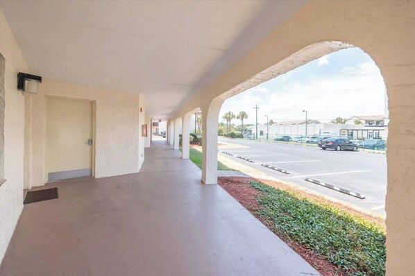 A covered corridor with a view of a parking lot and buildings in the distance. - Spacious Remodel|Bikes|Steps to Beach (St. Augustine)
