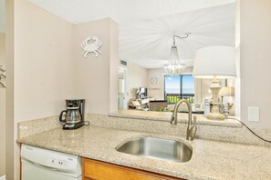 Enjoy cooking in the fully equipped kitchen with a granite countertop, stainless steel sink, and convenient coffee maker.