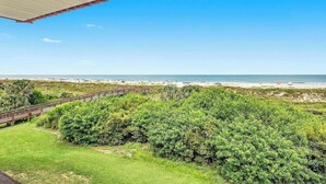 On peut admirer la plage depuis un espace abrité, et une passerelle en bois mène à la plage.