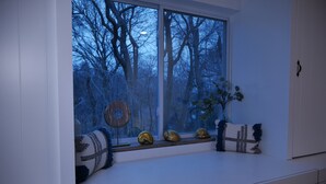 Ein Fensterplatz mit dekorativen Kissen und Muscheln.