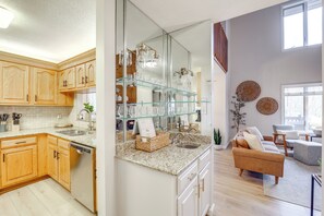 Enjoy a bright and airy kitchen with a dishwasher, light cabinetry, and a granite countertop.