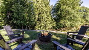 A backyard with a fire pit surrounded by Adirondack chairs. - Luxury 4BR in the Foothills · Lake & Trails · Sleeps 8 (Sedro-Woolley)