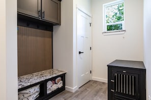 A laundry room with a countertop, a cabinet, a door, and a window. - Luxury 4BR in the Foothills · Lake & Trails · Sleeps 8 (Sedro-Woolley)