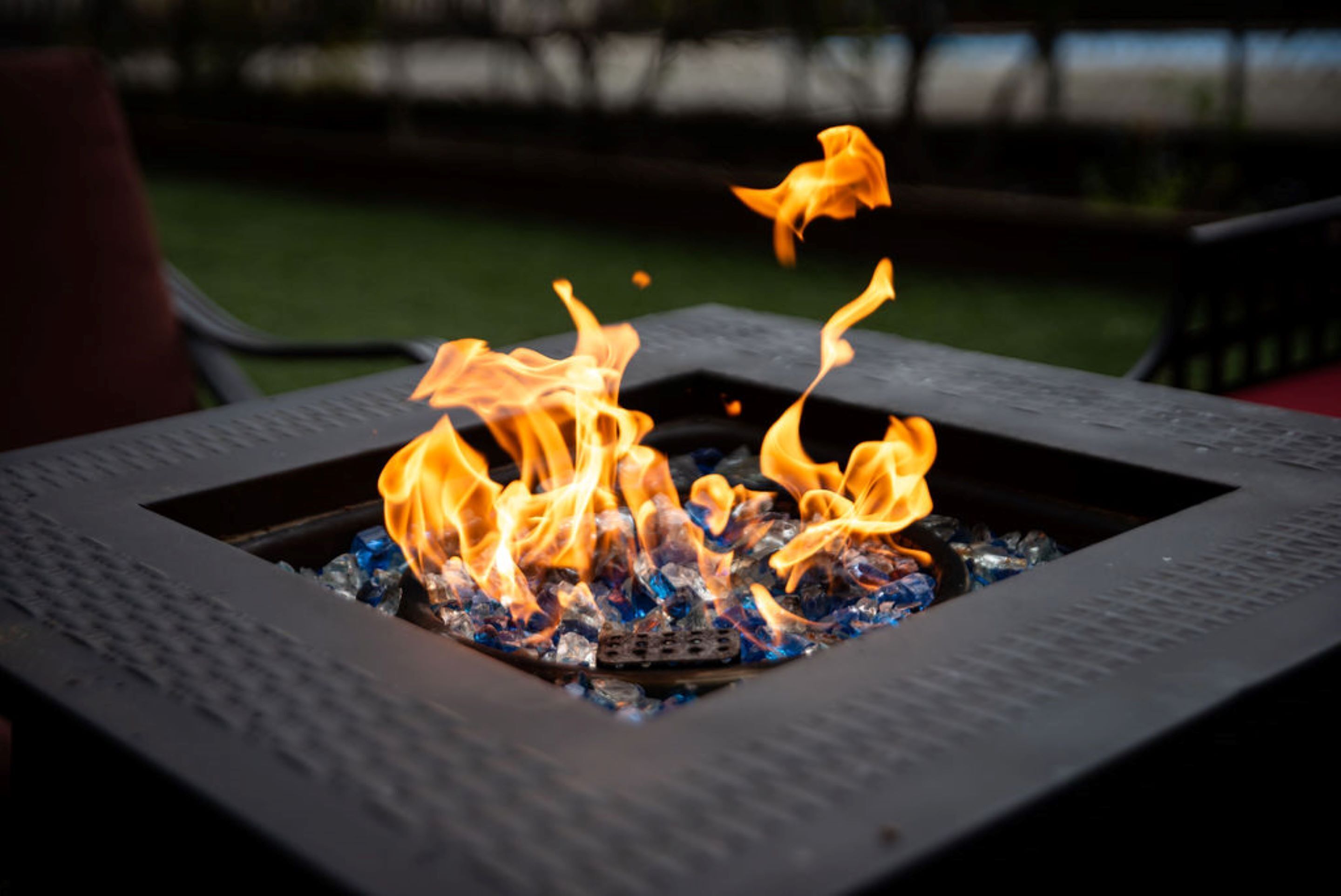 A square metal fire pit with flames.