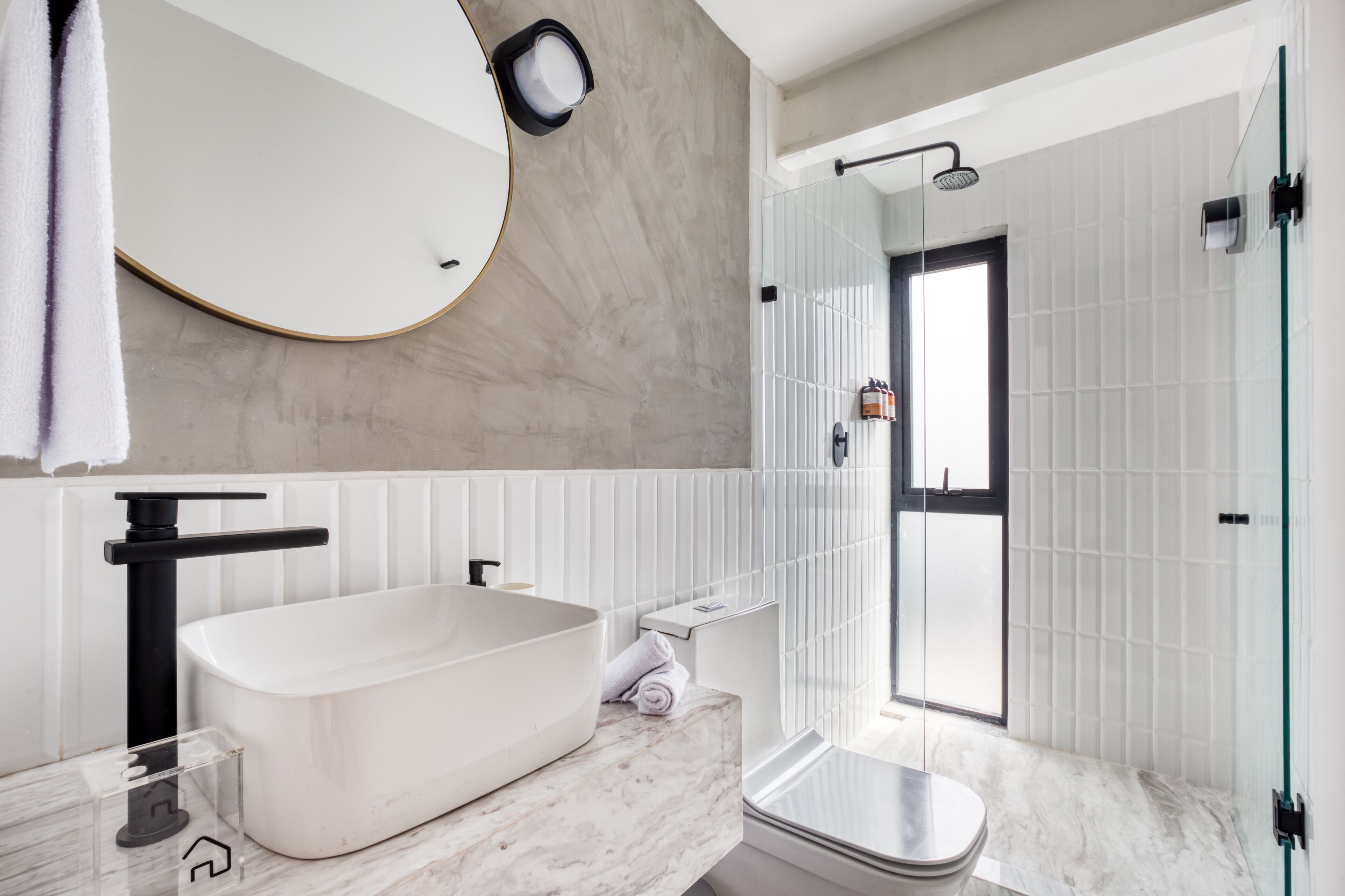 A modern bathroom with a freestanding bathtub, a glass shower enclosure, and a large mirror.