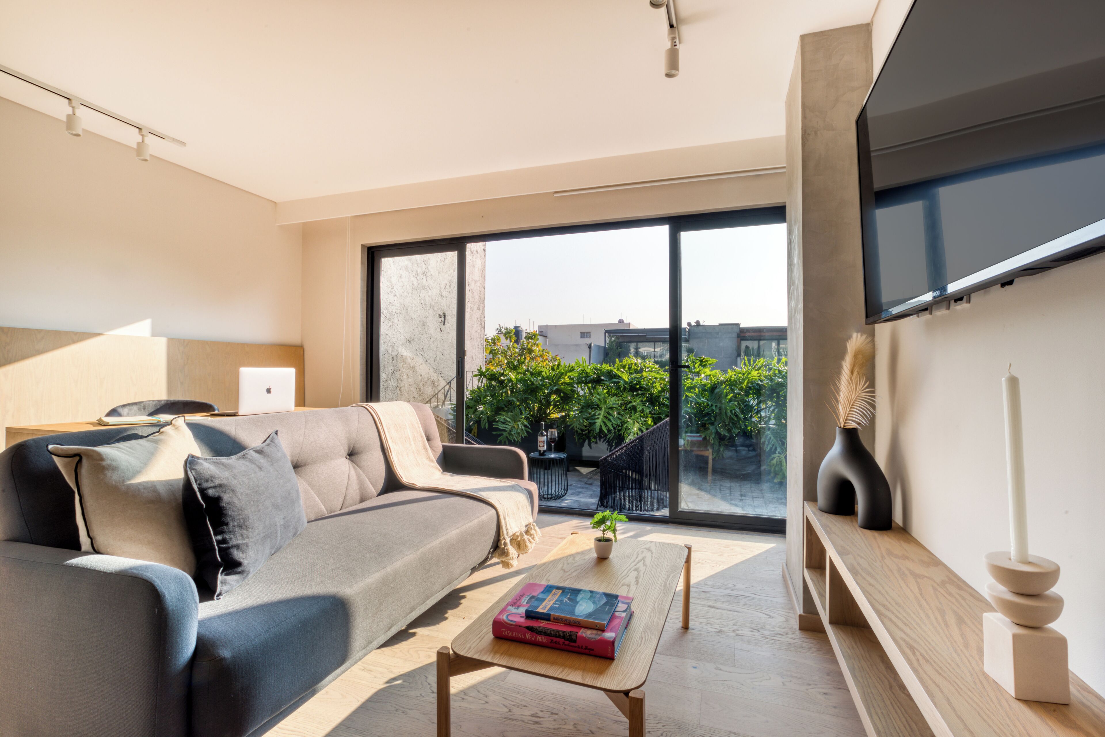 A modern living room with a sofa, coffee table, and a flat-screen TV.