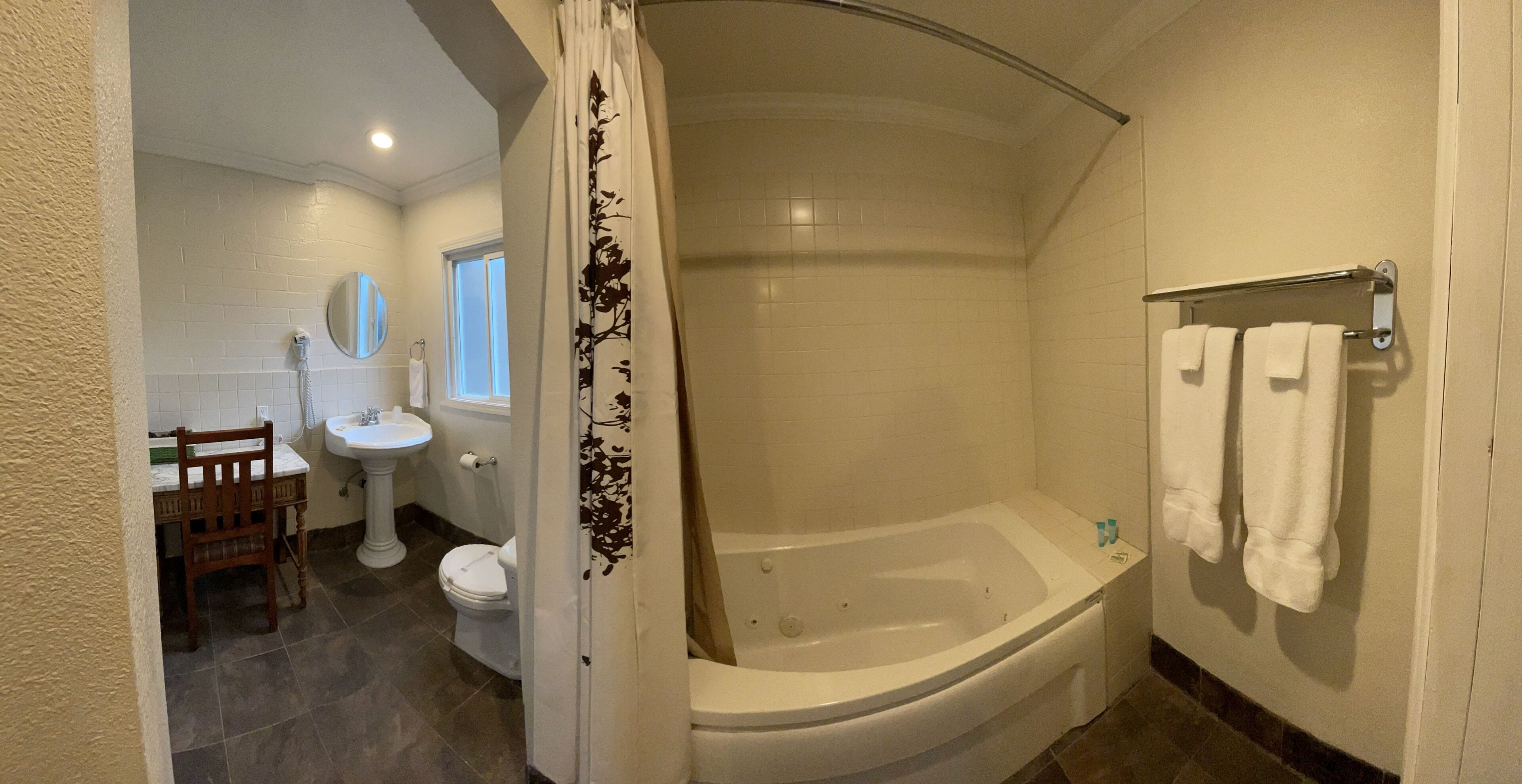 A bathroom with a bathtub, a toilet, a sink, and a mirror.
