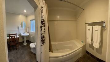 A bathroom with a bathtub, a toilet, a sink, and a mirror.