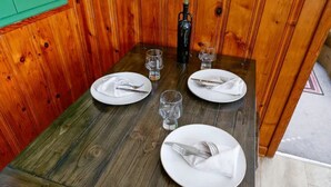 A wooden dining table set with white plates, silverware, and clear glasses. - Retro home minutes from downtown Denver (Denver)