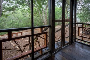 A wooden deck with a view of a forested area.