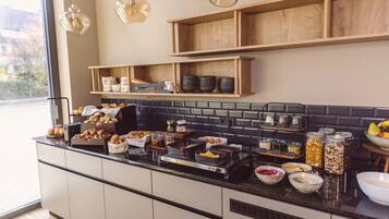 A kitchen with a buffet setup, including various food items and utensils on the counter.