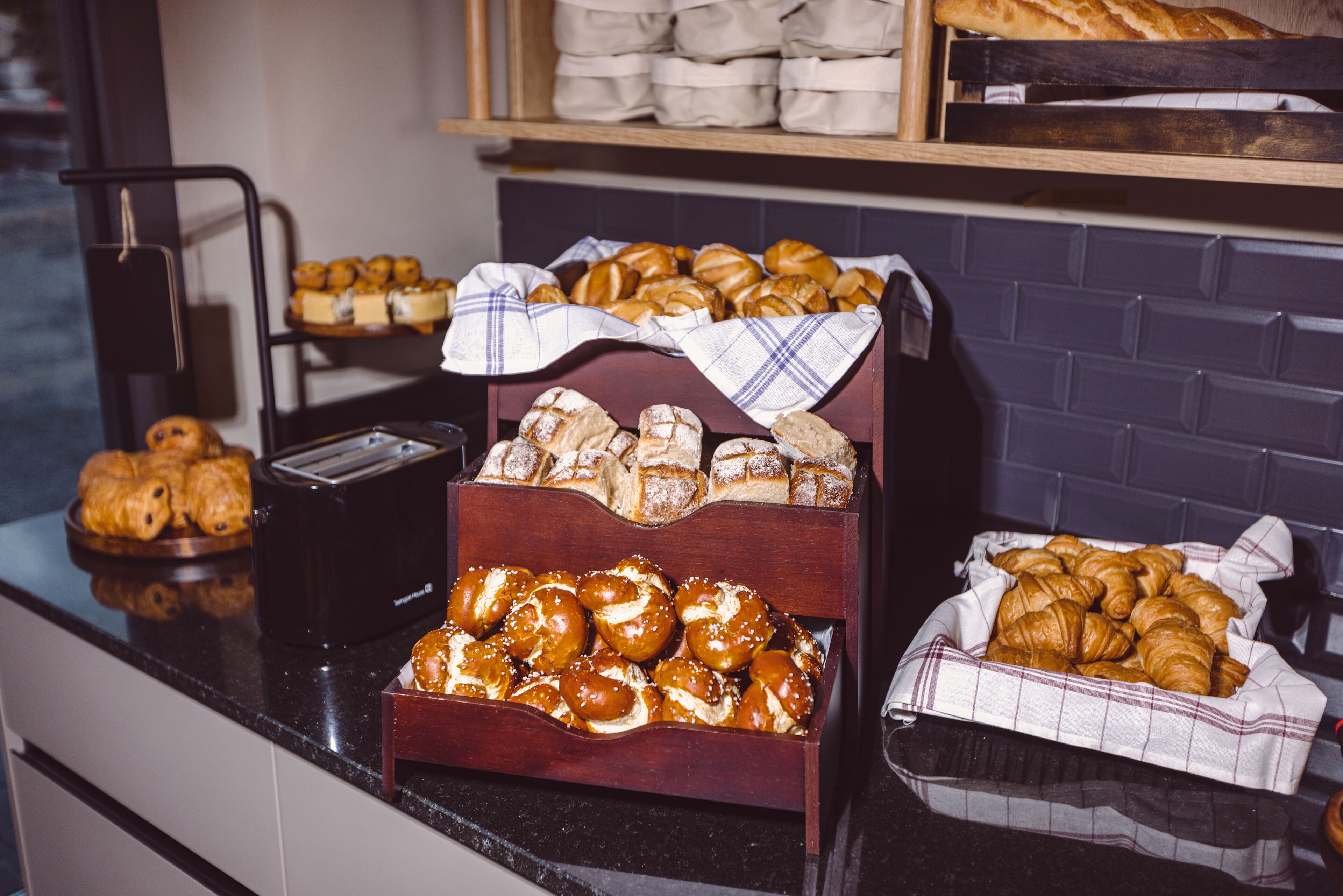 Eine Bäckereiauslage mit verschiedenen Backwaren, zum Beispiel Croissants und Brezeln.