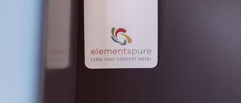 A hotel room door with a metal handle and a white card with the hotel name and logo.