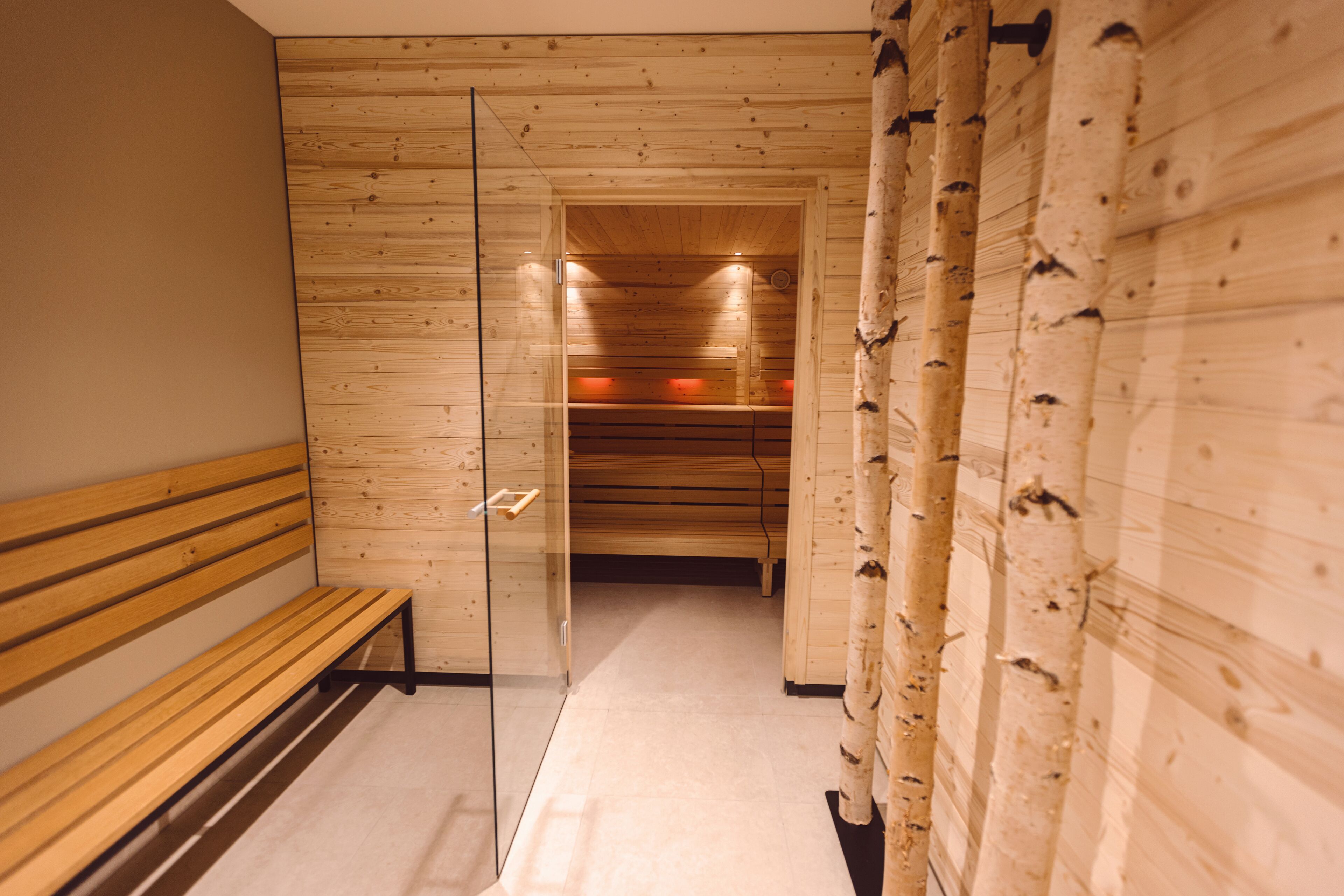 Ein Korridor mit Holzwandverkleidung, einer Glastür und einer Holzbank.